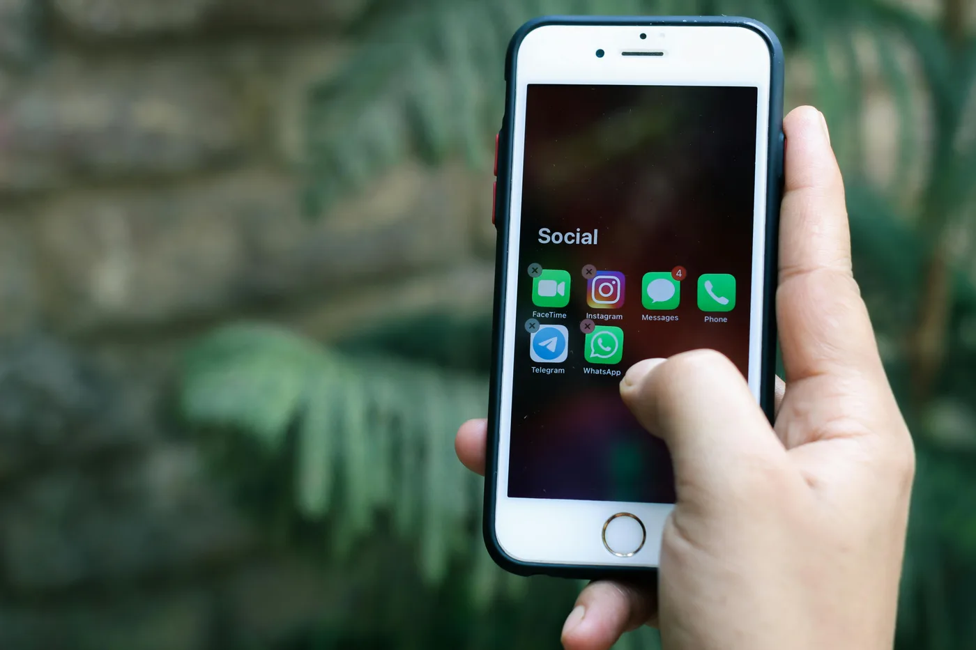 hand holding phone with social apps
