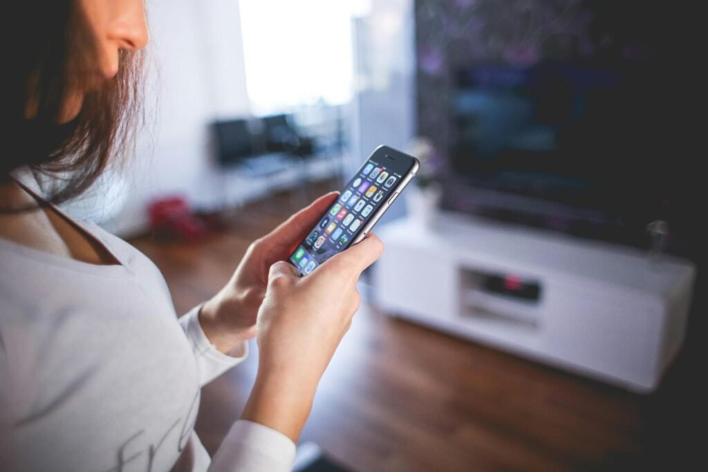 a woman holding her phone while at home
