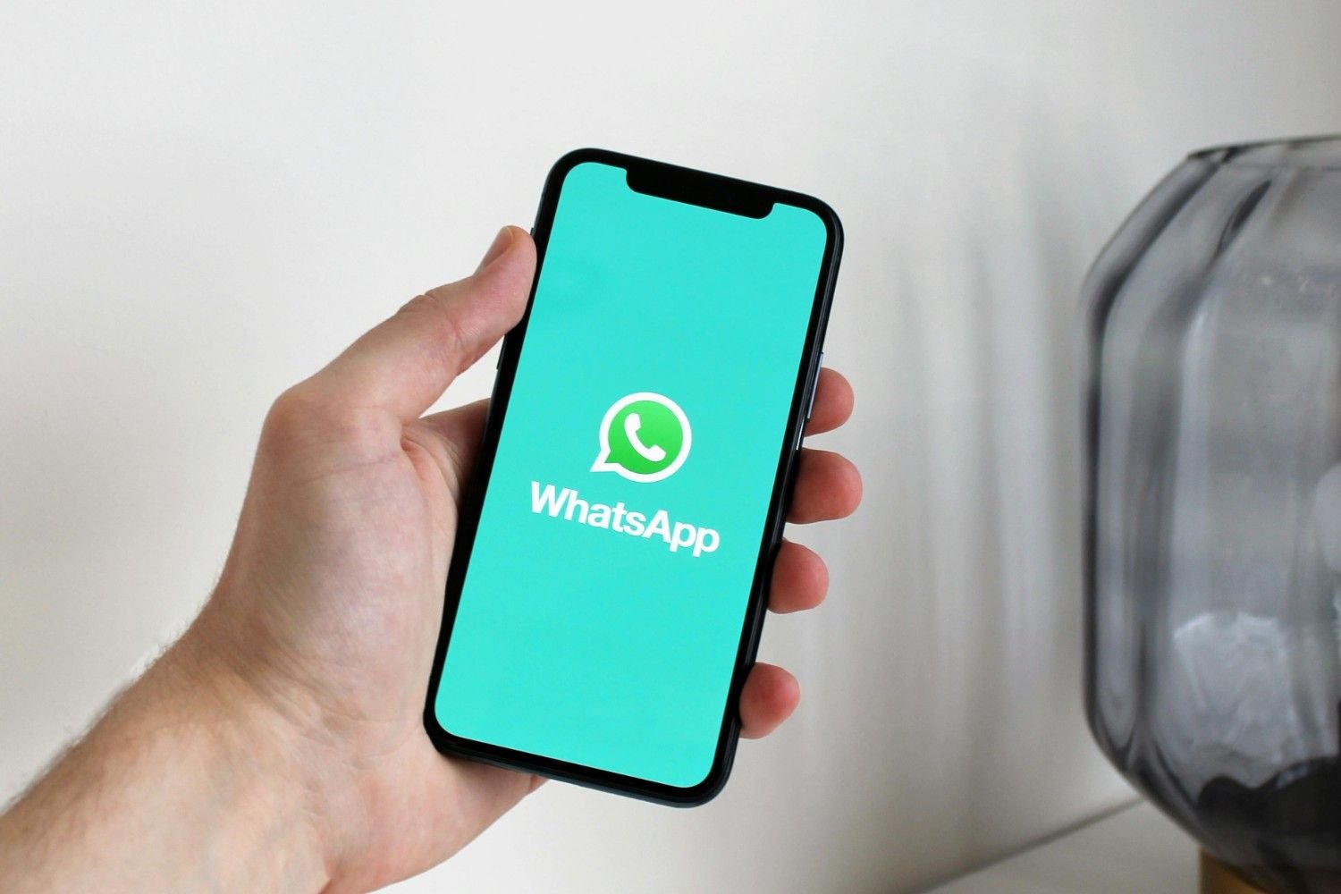 a person holding a phone with WhatsApp logo on the screen