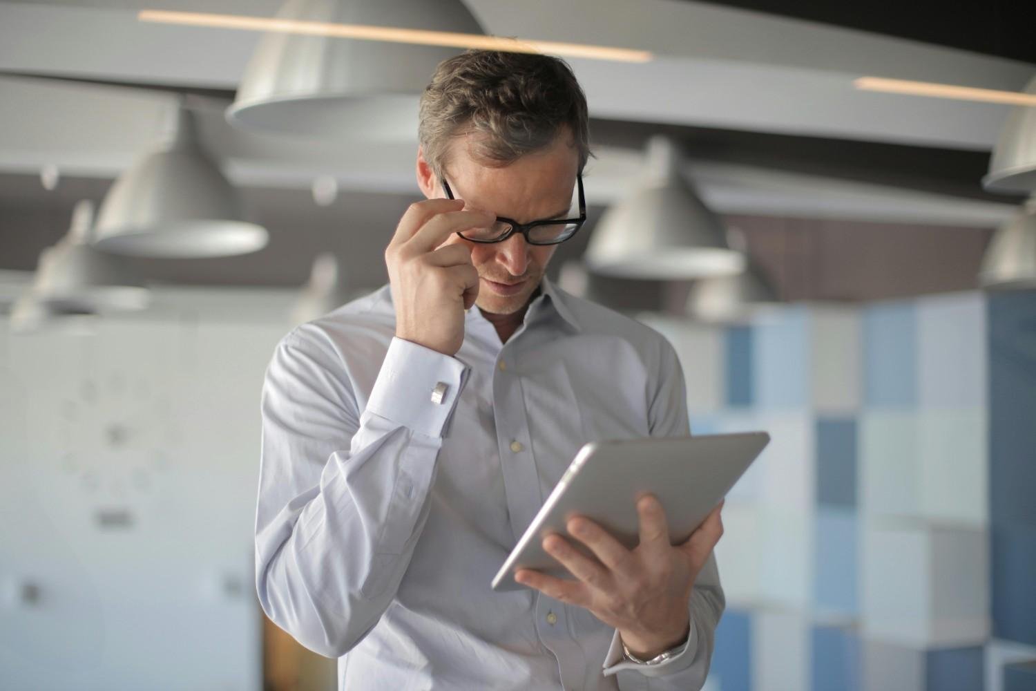 A man in the office reading using a tablet