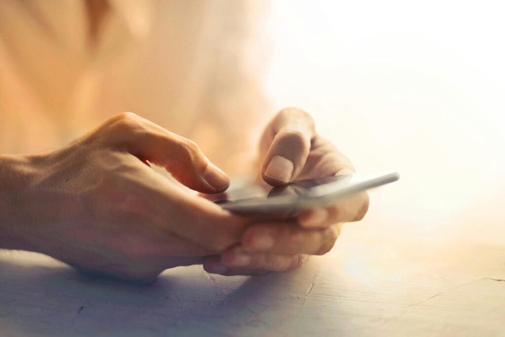 A person holding a smartphone on the table