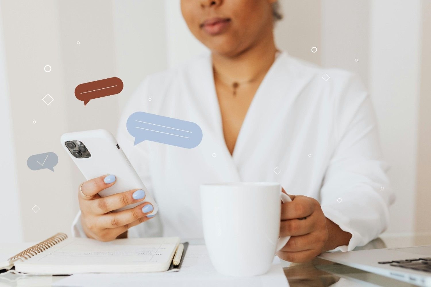 A person using a phone while holding a cup of coffee
